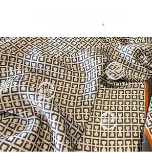 Detail of silk scarf showing black and white geometric pattern with orange trim fabric
