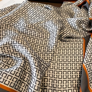Silk-like long scarf with black and white geometric patterns and orange border accents