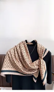 Dettaglio di sciarpa in seta twill con motivo ad anelli intrecciati su un manichino nero