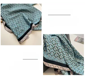 Dettaglio di un foulard in seta celeste con stampe geometriche a catena e bordi rifiniti