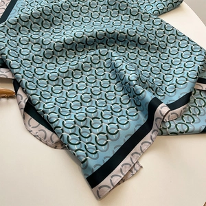 Dettaglio foulard in raso azzurro con cerchi geometrici e bordo a contrasto