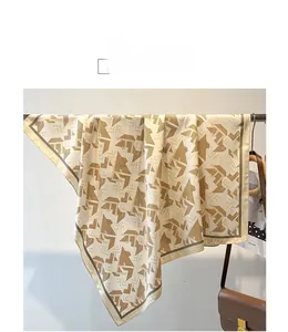 Detailed view of large twill silk scarf with geometric pattern and olive green edges