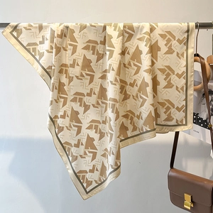 Detail of silk-like twill scarf with letter patterns hanging on a metal rack