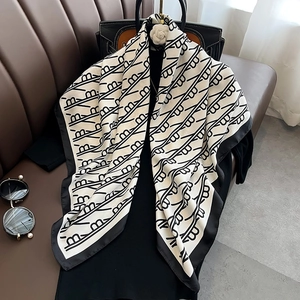 Carré de soie élégant à motif noir et blanc présenté avec des accessoires de luxe