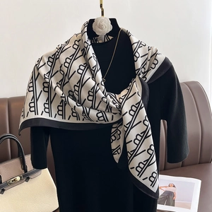 Détail d'un foulard en soie noir et blanc noué sur un mannequin avec motif géométrique