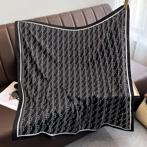 Gros plan d'un carré de soie noir et blanc avec motif monogramme B et armure sergé