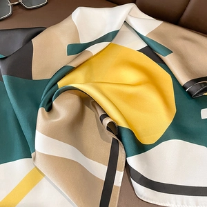 Detail of silk-like satin square scarf featuring a modern geometric color block design