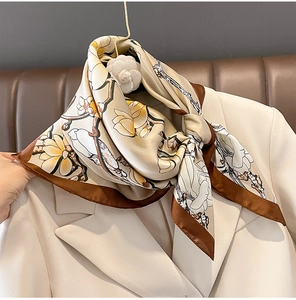 Detail eines Seidenschals mit Magnolienmuster an einem beigen Revers eines Anzugs
