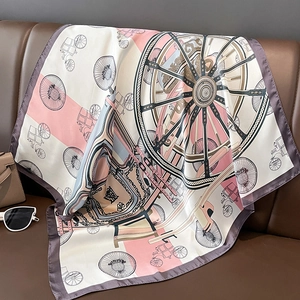 Close-up of a silk-feel square scarf with carriage print on a leather sofa surface