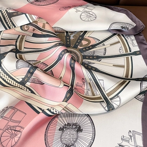 Detailed close-up of silk square scarf featuring vintage carriage and wheel patterns