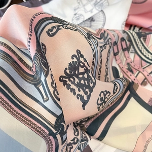 Macro shot of faux silk square scarf with classic horse carriage and bit pattern detail