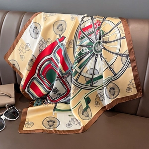 Close-up of vintage horse carriage pattern on luxury silk square scarf draped on sofa