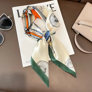 Elegant silk scarf with green and orange horse carriage patterns on white magazine background