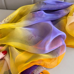 Detail of sheer gradient silk scarf showing soft texture and floral print patterns