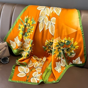 Elegant silk-like square scarf featuring sunflowers and leaves on an orange background
