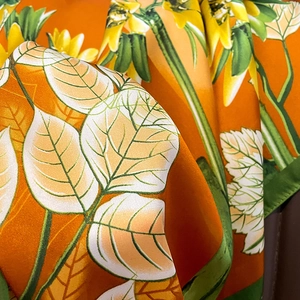 Detailed close-up showing vibrant sunflower print and satin texture of the square scarf