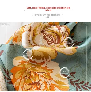 Détail d'un foulard en soie synthétique douce avec fond vert foncé et imprimé floral orange