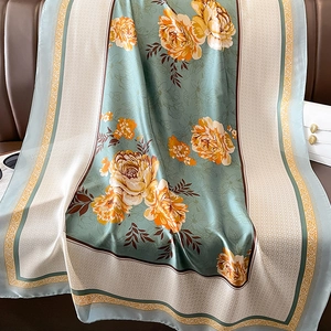 Châle en soie bleu vintage avec pivoines orange sur un fond de cuir élégant
