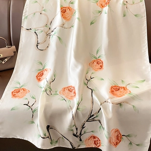 Elegant floral silk scarf featuring orange rose prints on a cream satin background