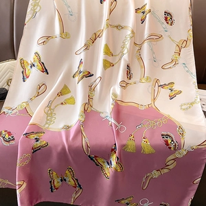 Detailed texture of silk scarf with elegant butterfly and gold chain patterns on gradient fabric