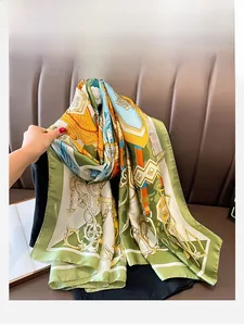 Detail of silk scarf with equestrian chain print in green and orange tones