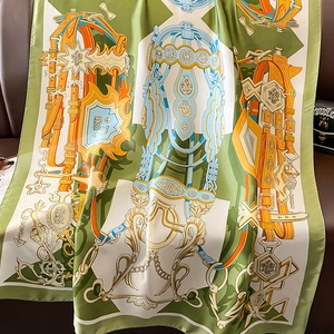Detailed pattern of horse bridle and medals on green silk scarf draped on leather sofa