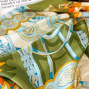 Macro detail of silk scarf with vintage equestrian print and smooth satin texture