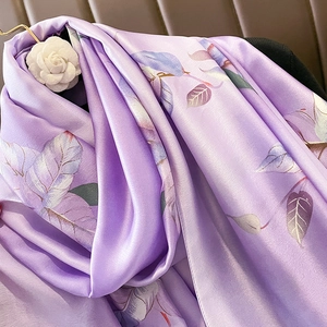 Détail d'une écharpe en satin violet avec motifs floraux élégants et texture soyeuse