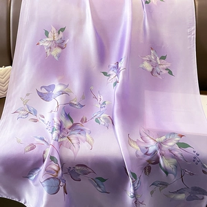 Vue détaillée de la texture soyeuse du foulard floral violet aux motifs élégants