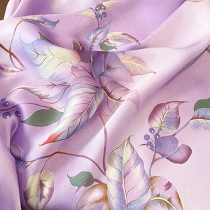 Gros plan du tissu de l'écharpe en soie lavande avec motifs feuilles et baies