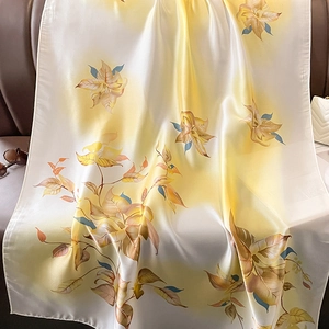 Gros plan détaillé du foulard en soie à fleurs jaunes avec dégradé et coutures délicates