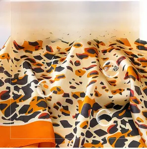 Detail of soft leopard print faux silk scarf with orange and black pattern texture