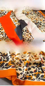 Detail showing the fine stitching edge and leopard print pattern on silk scarf