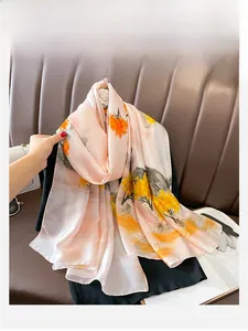 Detailed view of silk-like scarf with oriental tree print and soft glossy texture