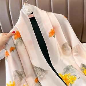 Detail of silk-like sun protection shawl with artistic orange tree and mountain prints