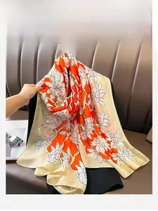 Detail of silk scarf with orange and champagne floral prints draped over black clothing