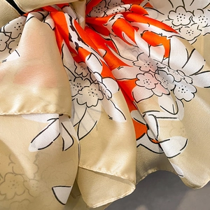 Detailed close-up of vibrant floral print scarf with silk texture and elegant draping