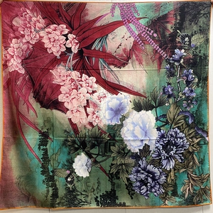 Detailed view of the colorful floral and bird pattern on a large square silk scarf