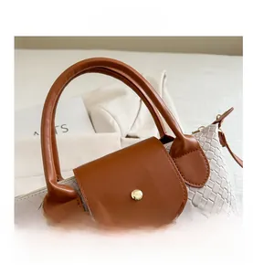 Detailed close-up of two-tone contrast bag with woven texture and gold metal buckle