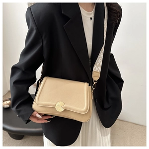 Detail of light beige crossbody bag with lychee texture and geometric wide strap