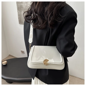 Close-up of white lychee leather shoulder bag with wide geometric woven strap and gold lock