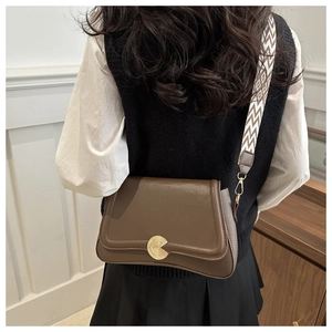 Brown leather crossbody bag with geometric woven strap and round gold metal buckle