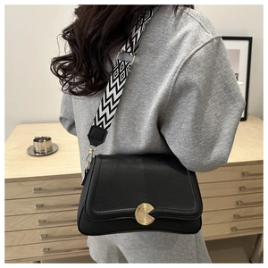 Detail of black lychee grain leather crossbody bag with geometric woven wide strap
