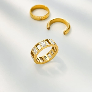 Macro shot of gold-plated ring set with trapezoid zircon and openwork heart patterns