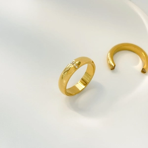 Detailed macro of a polished gold titanium ring featuring three vertical micro-set zircons