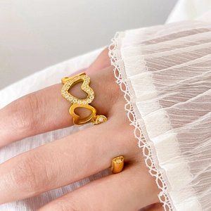 Close-up of gold heart-shaped ring with pavé zircon stones and lace sleeve detail