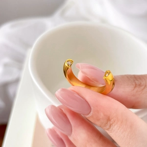 Close-up of a gold adjustable open ring featuring hollow heart designs and inlaid cubic zirconia