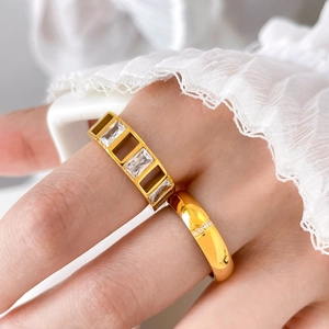 Close-up of gold titanium rings set with rectangular zircon and sparkling micro diamonds