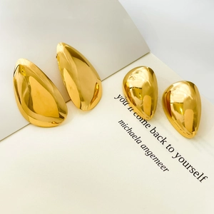 Detail of gold-plated stainless steel teardrop earrings with a high-polished mirror finish