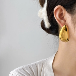 Polished 18K gold-plated stainless steel teardrop earrings worn by a model